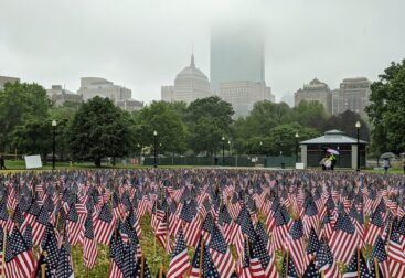 US flaglets at Boston Common with a foggy Boston urbanscape in the background